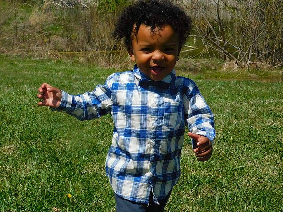 Lance is registered to the contest to win money with this photo: child, finger, fun, gesture, grass, grass_family, grassland, groundcover, hand, happy, lawn, meadow, people_in_nature, person, plant, sleeve, smile, soil, t_shirt, thumb