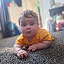 baby, child, infant, carpet, yellow_shirt, cute, indoors, person, toddler, floor, curious, wide_eyes, hand, hair, soft_light, home, blurred_background, crawling, skin, expression