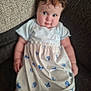 Edith is registered to the contest to win money with this photo: baby, child, dress, blue_butterfly, couch, curly_hair, indoor, person, portrait, seated, soft_focus, white_dress, infant, cute, chubby_cheeks, expression, young_child, comfortable, casual, relaxed