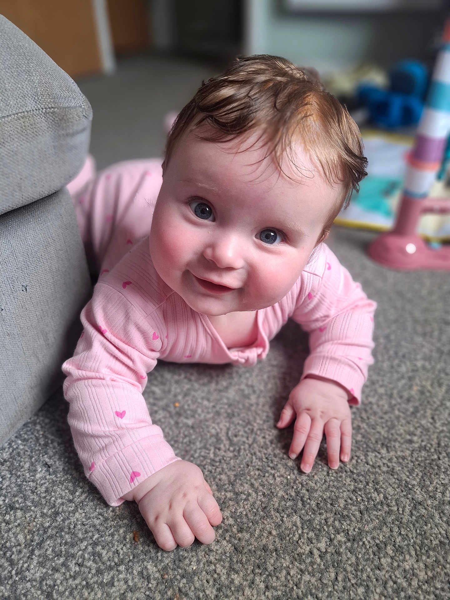 Edith joined the competition — help win amazing prizes! baby, infant, crawling, pink_clothing, carpet, indoor, smiling, child, cute, closeup, face, hand, floor, home, person, young_child, playful, curious, soft_light, living_room