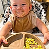baby, child, high_chair, messy_face, bib, scrambled_eggs, food, plate, smiling, happy, indoor, meal_time, toddler, cute, face, hands, eating, kitchen, food_mess, infant