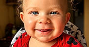 Jermaine is registered to the contest to win money with this photo: toddler, child, smiling, curly_hair, blue_eyes, red_shirt, mickey_mouse, high_chair, indoor, portrait, happy, cute, baby, person, clothing, face, expression, seated, warm_lighting, home