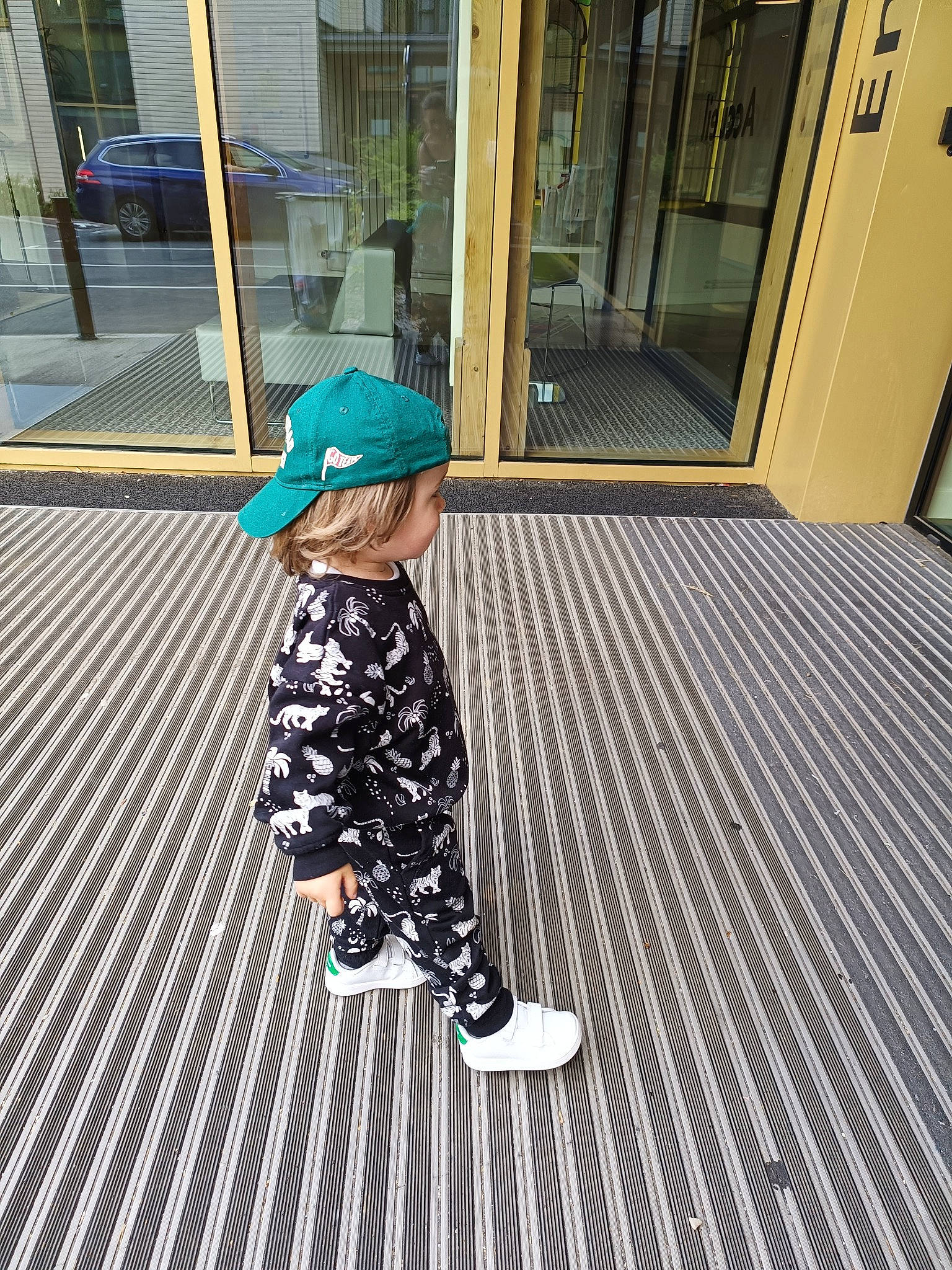 Juan participe au concours pour gagner de l'argent avec cette photo : asphalt, cap, child, composite_material, door, fashion_accessory, floor, flooring, hardwood, hat, human_leg, metal, pattern, pedestrian, person, road_surface, sidewalk, sleeve, tints_and_shades, toddler
