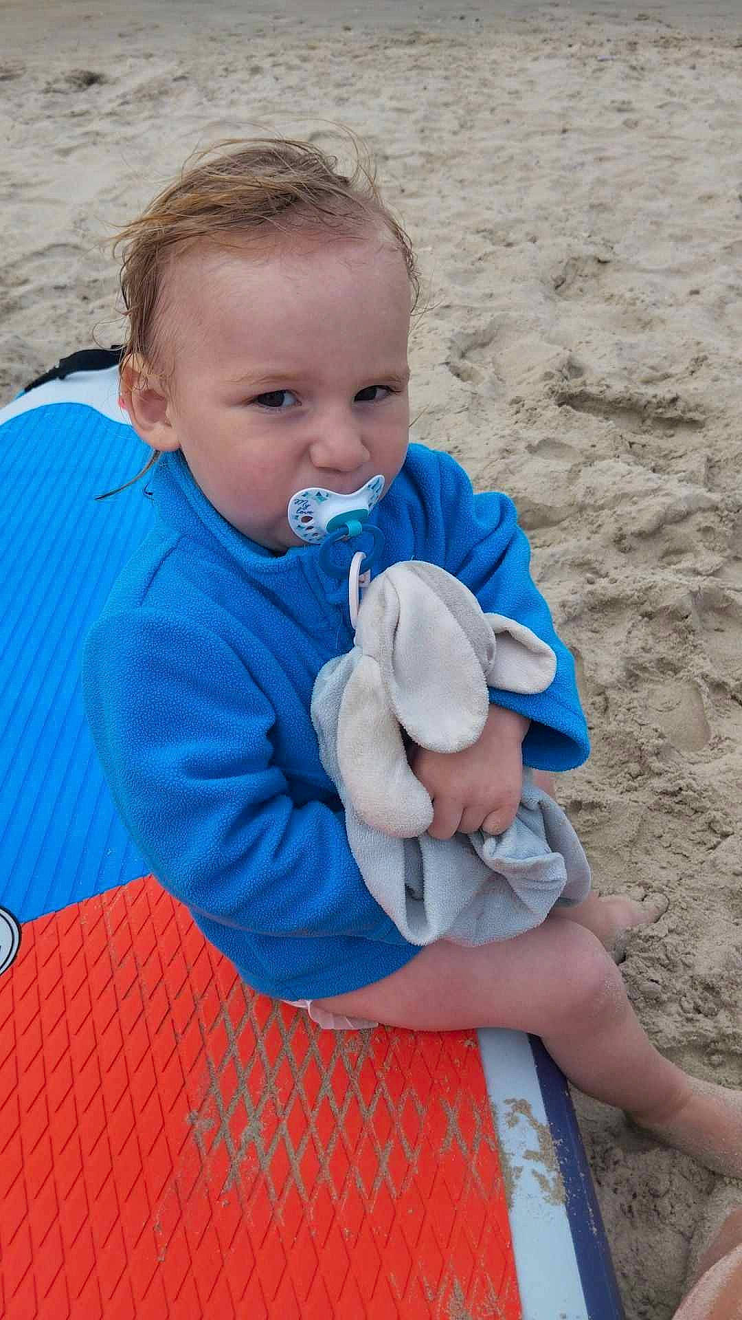 Louka a rejoint le concours — aidez-le/la à gagner de superbes lots ! azure, baby, baby_products, baby_toddler_clothing, beach, child, comfort, electric_blue, fun, grass, happy, leisure, ocean, person, play, sand, sitting, skin, toddler, vacation