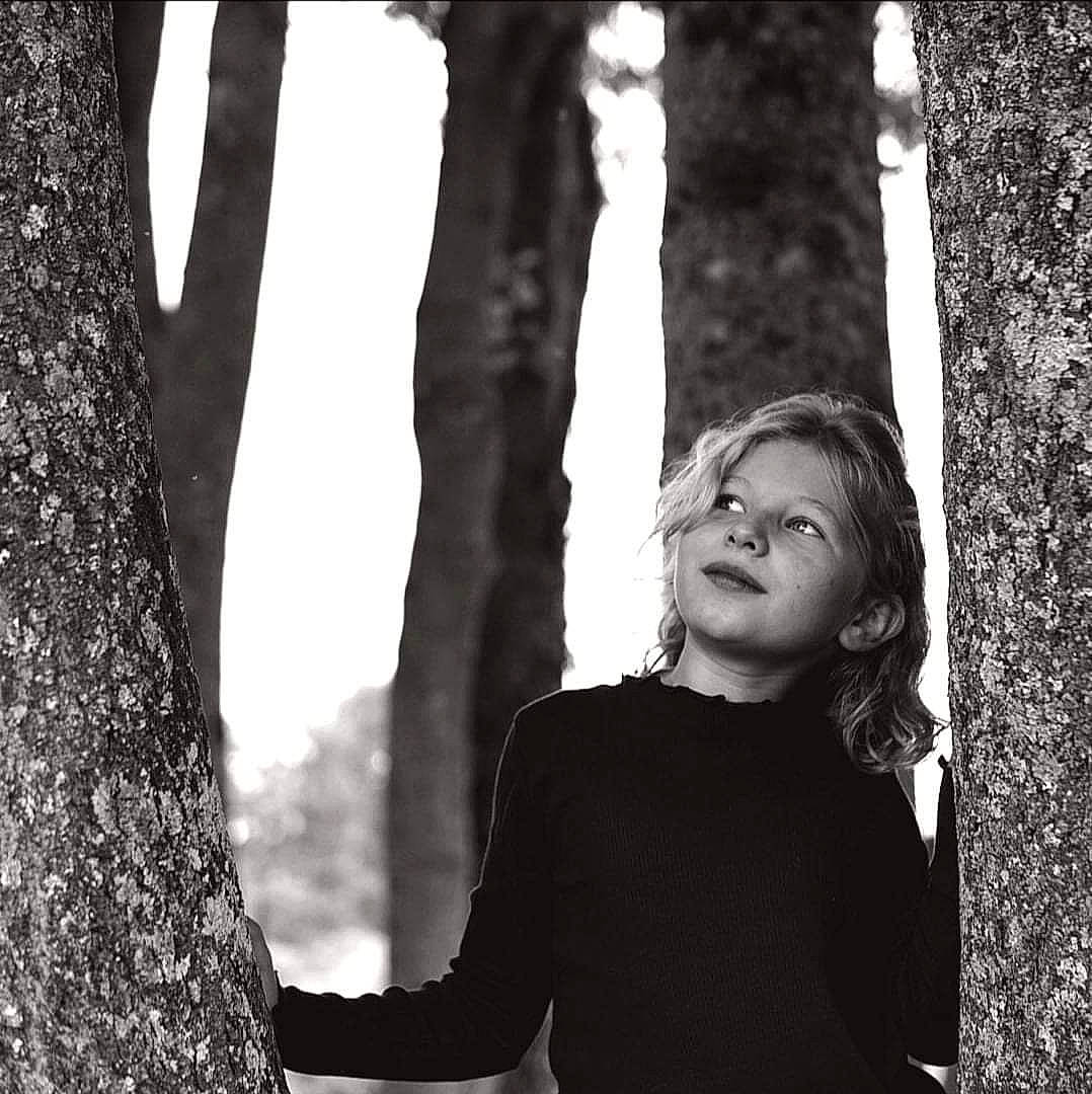 Hodéi participe au concours pour gagner de l'argent avec cette photo : adaptation, black, black_and_white, facial_expression, flash_photography, gesture, hairstyle, happy, human, human_body, monochrome, monochrome_photography, people_in_nature, person, standing, style, tints_and_shades, tree, trunk, white