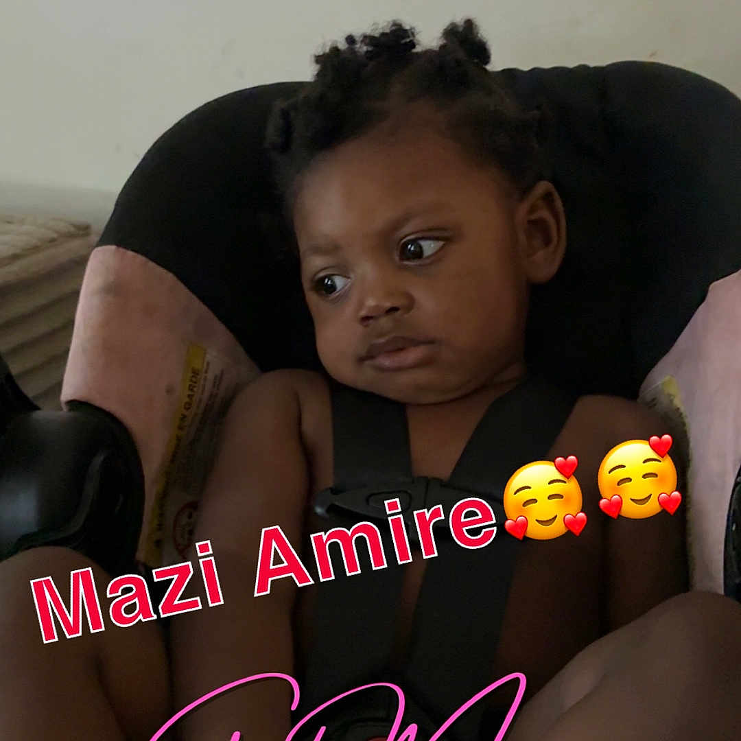 Mazi joined the competition — help win amazing prizes! toddler, child, car_seat, seatbelt, indoor, looking_away, black_hair, braids, expression, thinking, skin, hand, foot, text_overlay, emoji, casual, portrait, young_child, seat, sitting