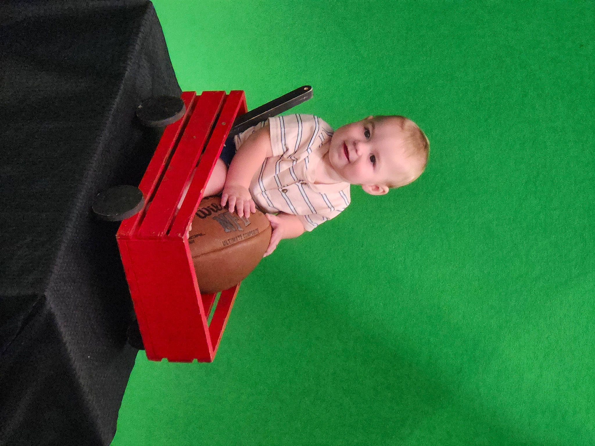 Bradley is registered to the contest to win money with this photo: baby, baby_products, baby_toddler_clothing, carmine, child, comfort, flooring, fun, grass, joy, magenta, paper, paper_product, person, room, sitting, toddler, wood