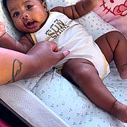 Ava-Rose joined the competition — help win amazing prizes! baby, infant, onesie, baby_seat, hand, tattoo, pink_nails, curly_hair, smiling, lying_down, blanket, hello_kitty, cushion, baby_bedding, child, cute, indoor, comfort, expression, person
