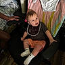Carson joined the competition — help win amazing prizes! baby, child, bib, chair, socks, shorts, shirt, indoor, towel, hand, floor, person, furniture, wooden_floor, cup, pillow, blanket, black_chair, clothing, footwear