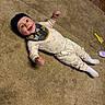 Carson joined the competition — help win amazing prizes! baby, smiling, lying_down, carpet, indoor, hat, pajamas, toy, brush, bottle, child, cute, happy, cozy, floor, infant, person, playful, clothing, headwear