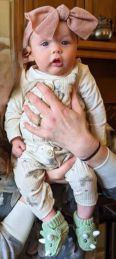 Charlotte is registered to the contest to win money with this photo: baby, baby_toddler_clothing, cap, cheek, child, eyelash, fashion_accessory, finger, gesture, hand, happy, headwear, jewellery, nail, person, sitting, skin, sleeve, thumb, toddler