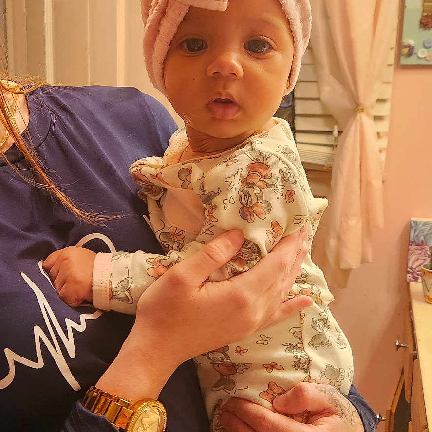 Mahaly is registered to the contest to win money with this photo: accessories, baby, bodypart, bonnet, cap, clothing, cup, dress, face, finger, hand, hardwood, hat, head, newborn, person, photography, plywood, portrait, wood
