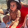 baby, toddler, child, bucket_hat, hat, phone, smartphone, baby_bottle, sippy_bottle, red_seat, adult, man, arm, sneaker, nike, outdoors, sunny, portrait, sitting, curious_expression