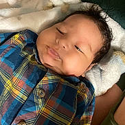 Jeyder Fernandez is registered to the contest to win money with this photo: baby, infant, plaid_shirt, face, lying_down, blanket, soft_texture, cozy, cute, child, portrait, sleepy, smile, indoors, person, clothing, skin, head, hair, young