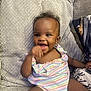 Kaija is registered to the contest to win money with this photo: baby, smiling, couch, colorful_clothing, happy, infant, indoor, person, child, cute, portrait, sitting, furniture, home, soft_texture, young_child, cheerful, bright_eyes, fun, cozy