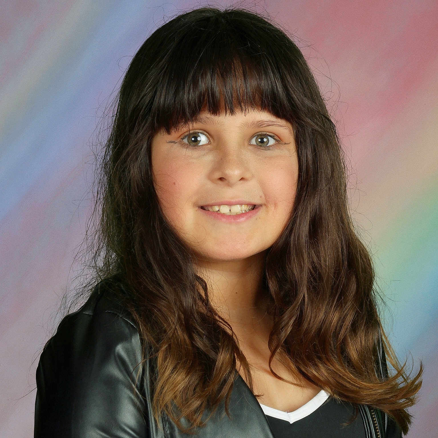 Justine is registered to the contest to win money with this photo: bangs, black_clothing, casual_wear, child, colorful_background, eyes, face, fashion, girl, hair, happy, indoor, leather_jacket, long_hair, pastel_background, person, portrait, smiling, studio_photo, young