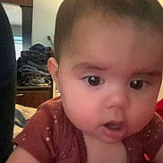 Ellie is registered to the contest to win money with this photo: baby, close_up, face, child, indoors, curious, clothing, bedroom, mirror, furniture, young_child, person, infant, cute, expression, skin, hair, eyes, red_clothing, home