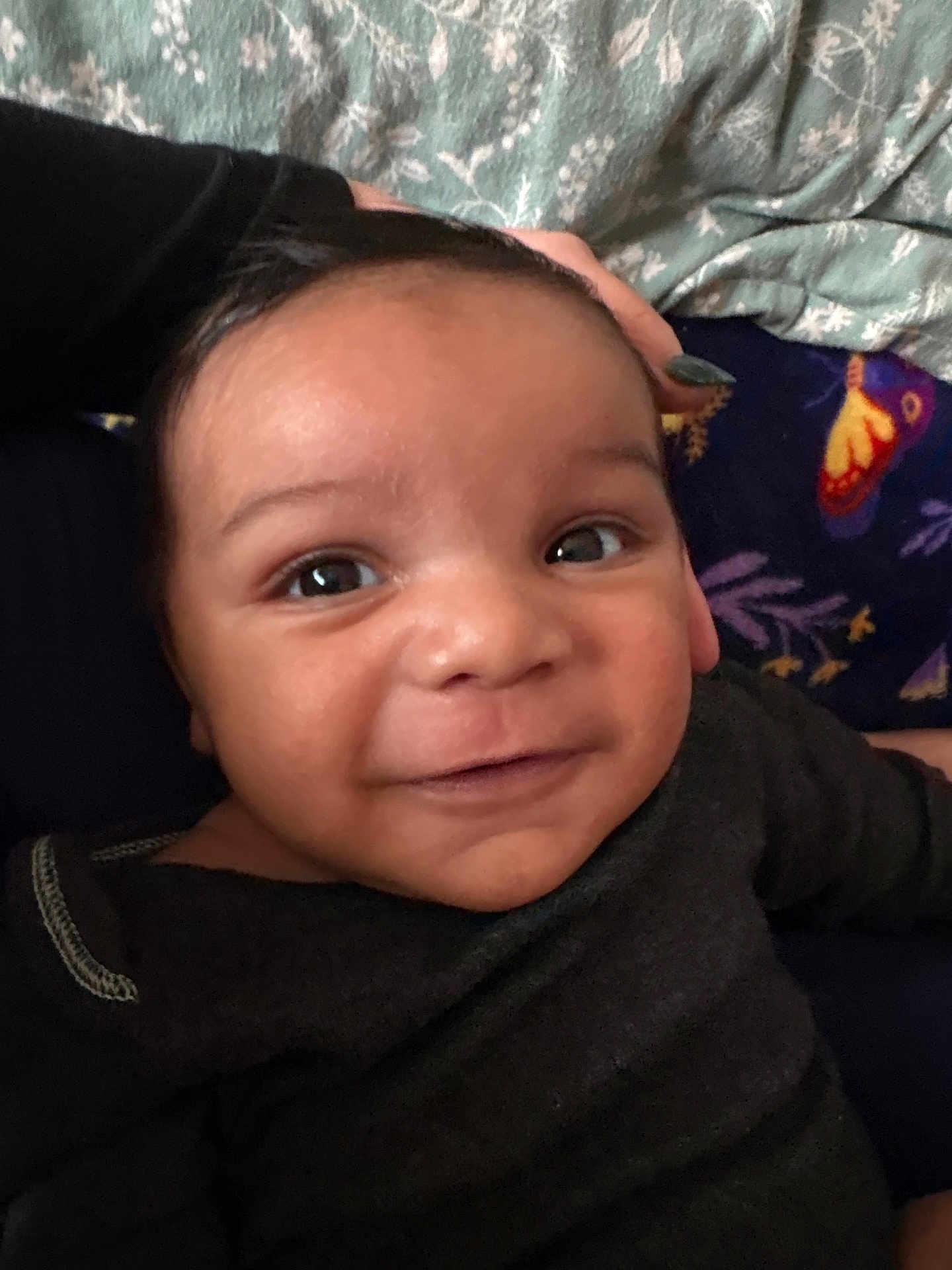 Mason joined the competition — help win amazing prizes! baby, infant, child, smile, face, eyes, portrait, close_up, indoors, blanket, bedding, hand, nail_polish, clothing, onesie, skin, cute, happy, parent, background_pattern