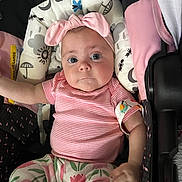Elena joined the competition — help win amazing prizes! baby, car_seat, child, child_seat, closeup, clothing, cute, expression, face, floral_pants, headband, indoor, infant, patterned_fabric, pink_bow, portrait, seatbelt, small_hand, soft_lighting, striped_shirt
