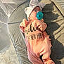 baby, infant, pacifier, pink_onesie, bow_hat, mesh_playpen, cushion, gray_cushion, baby_clothing, newborn, indoor, soft_light, shadow, sleepwear, child, cute, resting, portrait, baby_accessory, cozy