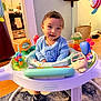 Jonathan is registered to the contest to win money with this photo: toddler, child, infant_activity_center, toy, smiling, indoor, home, play, clothing, face, person, carpet, furniture, kitchen, bag, mirror, sock, plastic_toy, floor, cute