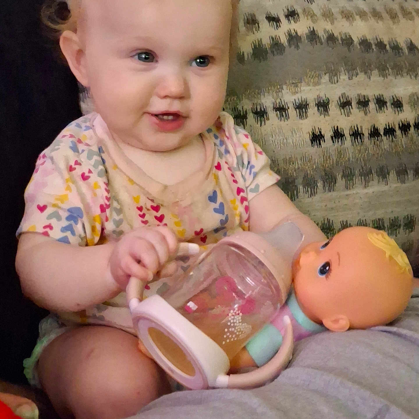 Bry-Lynn Biles is registered to the contest to win money with this photo: baby, bottle, child, clothing, couch, cute, doll, expression, face, hand, home, indoor, patterned_cushion, person, playing, relaxing, sitting, smiling, toddler, toy