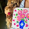 Princesse participe au concours pour gagner de l'argent avec cette photo : dog, yorkshire_terrier, small_dog, pet, puppy, long_hair, brown_fur, floppy_ears, black_nose, brown_eyes, person, child, cuddling, portrait, flower_painting, canvas, bouquet, blue_vase, indoors, colorful