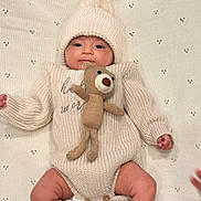 Aryansh joined the competition — help win amazing prizes! baby, infant, knitted_hat, knitted_outfit, plush_toy, teddy_bear, blanket, cute, soft_texture, indoors, portrait, child, smiling, lying_down, warm_clothing, newborn, comfortable, small_hands, small_feet, cozy