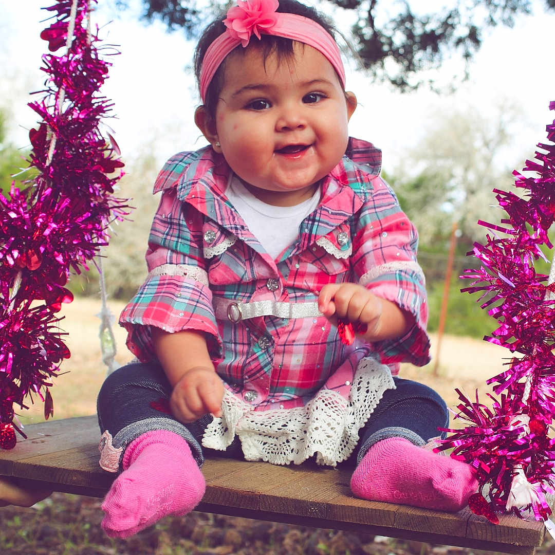 Raygen is registered to the contest to win money with this photo: botany, cheek, child, flower, fun, grass, happy, headgear, leaf, magenta, person, photography, pink, plant, play, purple, sitting, smile, spring, toddler