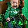 Liam is registered to the contest to win money with this photo: baby, child, green_shirt, st_patricks_day, chair, wooden_chair, clover, shamrock, green_lights, festive, holiday, smiling, jeans, indoor, portrait, cute, person, celebration, plant, decorations