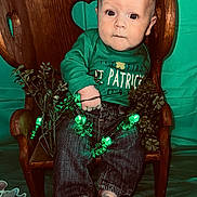 Liam joined the competition — help win amazing prizes! baby, child, green_clothing, st_patricks_day, wooden_chair, heart_cutout, green_lights, shamrocks, plants, indoor, barefoot, jeans, cute, portrait, sitting, holiday, celebration, background, decor, expression