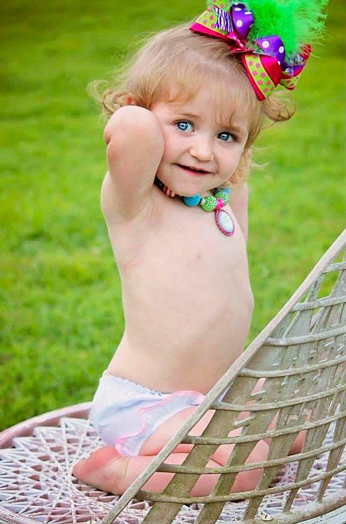 Sam is registered to the contest to win money with this photo: baby, baby_bloomers, baby_toddler_clothing, child, child_model, dress, fashion_accessory, fun, grass, hair_accessory, happy, headband, headgear, pattern, person, photography, pink, skin, smile, summer