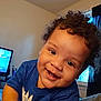 Adrian is registered to the contest to win money with this photo: toddler, child, smiling, curly_hair, blue_shirt, indoor, window, television, happy, face, closeup, person, young_child, expression, portrait, candid, baby, skin, head, cheerful