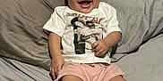 Isabella joined the competition — help win amazing prizes! baby, bed, child, clothing, comfortable, cute, happy, headwrap, indoor, infant, person, pillow, portrait, shorts, sitting, skin, smiling, socks, tshirt, young