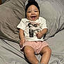 Isabella joined the competition — help win amazing prizes! baby, child, smiling, sitting, bed, pillow, headwrap, tshirt, shorts, socks, happy, infant, portrait, indoor, person, cute, comfortable, skin, clothing, young