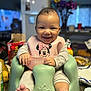 Isabella is registered to the contest to win money with this photo: baby, smiling, infant, bib, minnie_mouse, baby_seat, gray_pajamas, happy, indoor, kitchen, furniture, child, person, cute, feet, hands, table, food, colorful, portrait