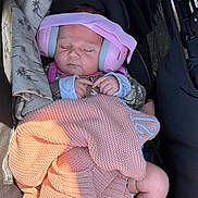 Bristol is registered to the contest to win money with this photo: baby, blanket, child, clothing, comfort, cozy, cute, headphones, indoors, infant, peaceful, pink, portrait, relaxing, resting, sleeping, soft, stroller, wrapped, young