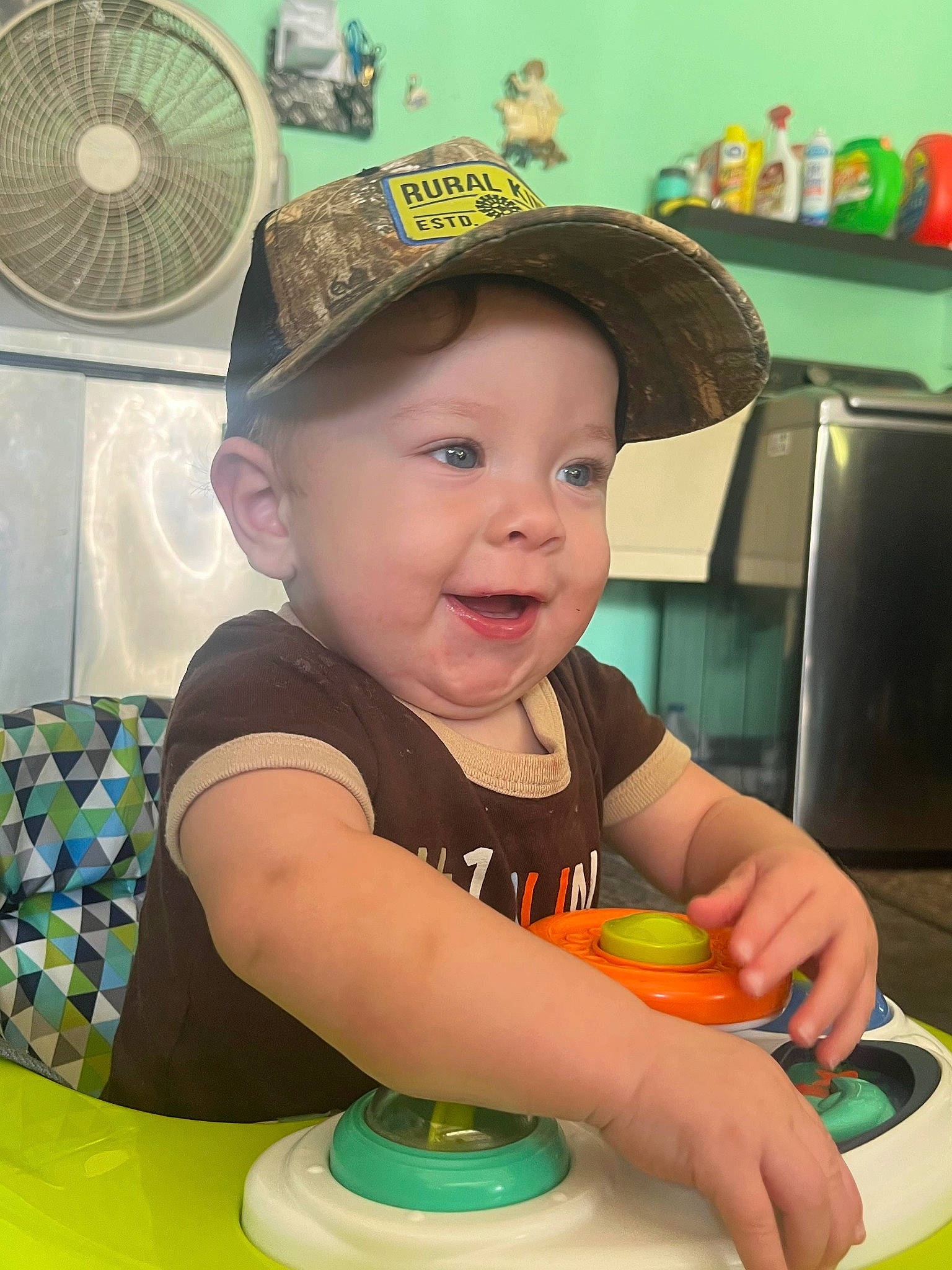 Titus joined the competition — help win amazing prizes! baby, baby_playing_with_toys, baby_toddler_clothing, baseball_cap, cap, child, fashion_accessory, fun, green, happy, hat, headwear, leisure, mechanical_fan, person, plastic, sitting, skin, smile, table