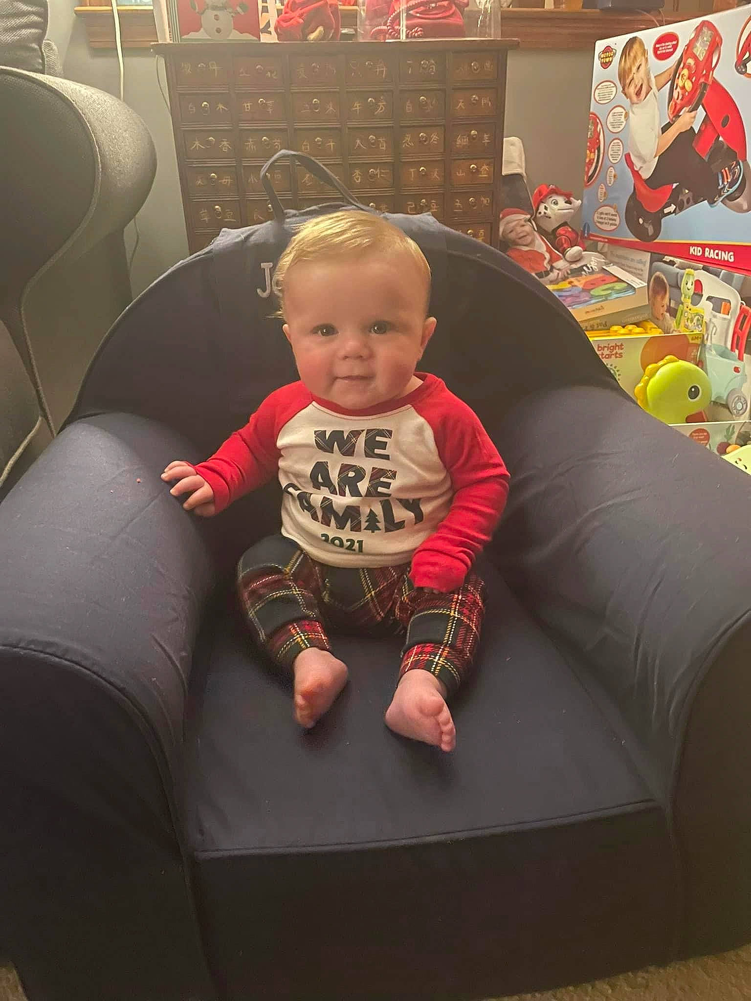 Jameson joined the competition — help win amazing prizes! baby, chair, child, comfort, couch, flooring, fun, knee, lap, living_room, person, recreation, red, room, sitting, sofa_bed, t_shirt, toddler, visual_arts