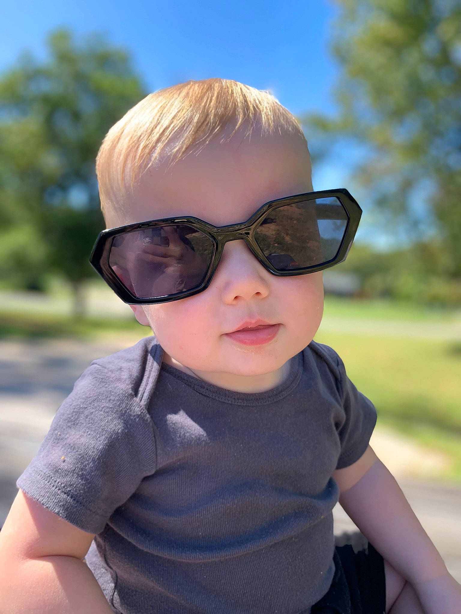 Sailor is registered to the contest to win money with this photo: baby_toddler_clothing, cool, eye_glass_accessory, eyewear, fun, glasses, goggles, grass, happy, lip, person, personal_protective_equipment, pink, plant, skin, sky, sunglasses, t_shirt, toddler, tree