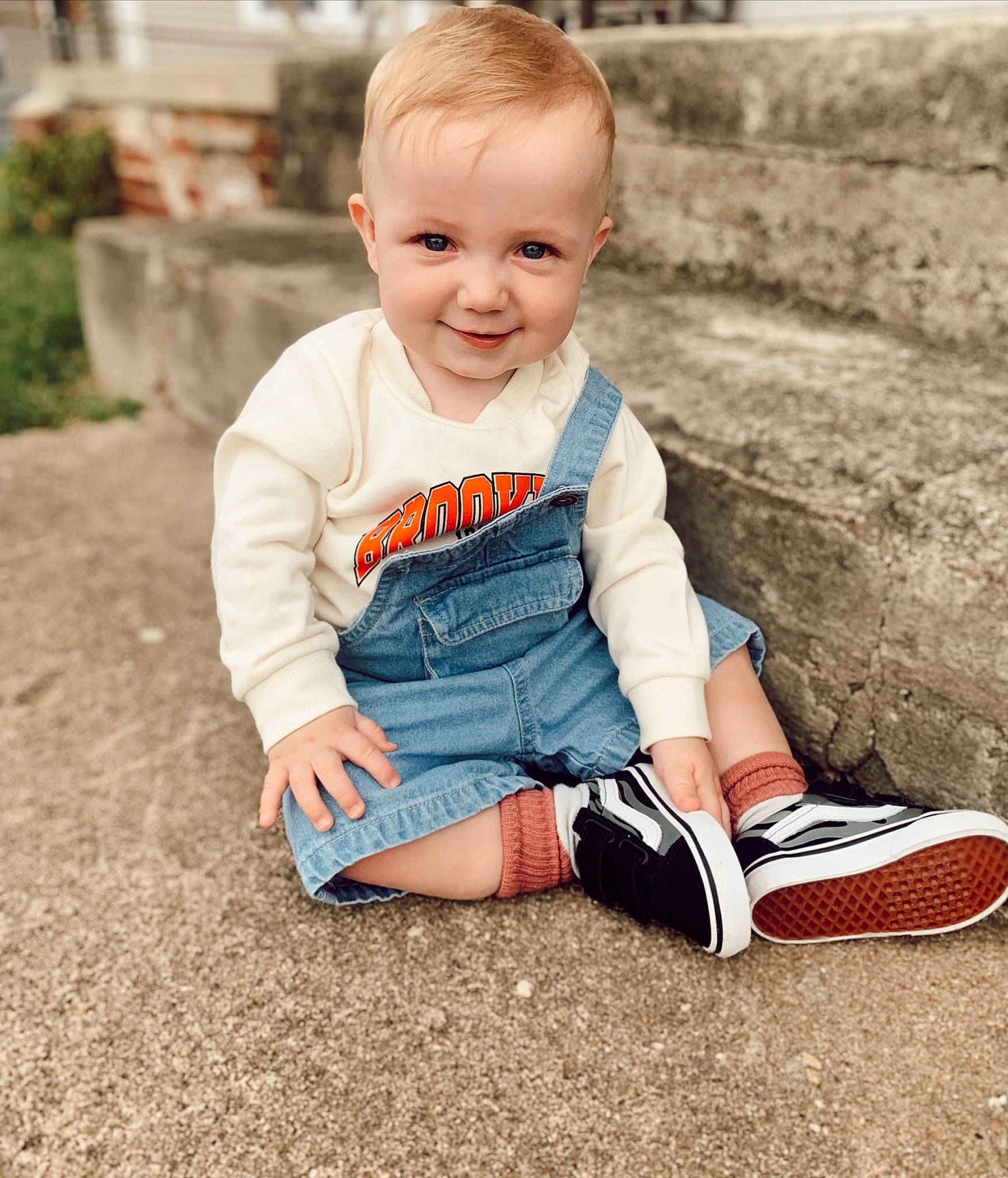 Sailor is registered to the contest to win money with this photo: baby, baby_toddler_clothing, child, electric_blue, face, fun, grass, hairstyle, happy, human_leg, joy, knee, pattern, people_in_nature, person, plant, sitting, sleeve, smile, soil
