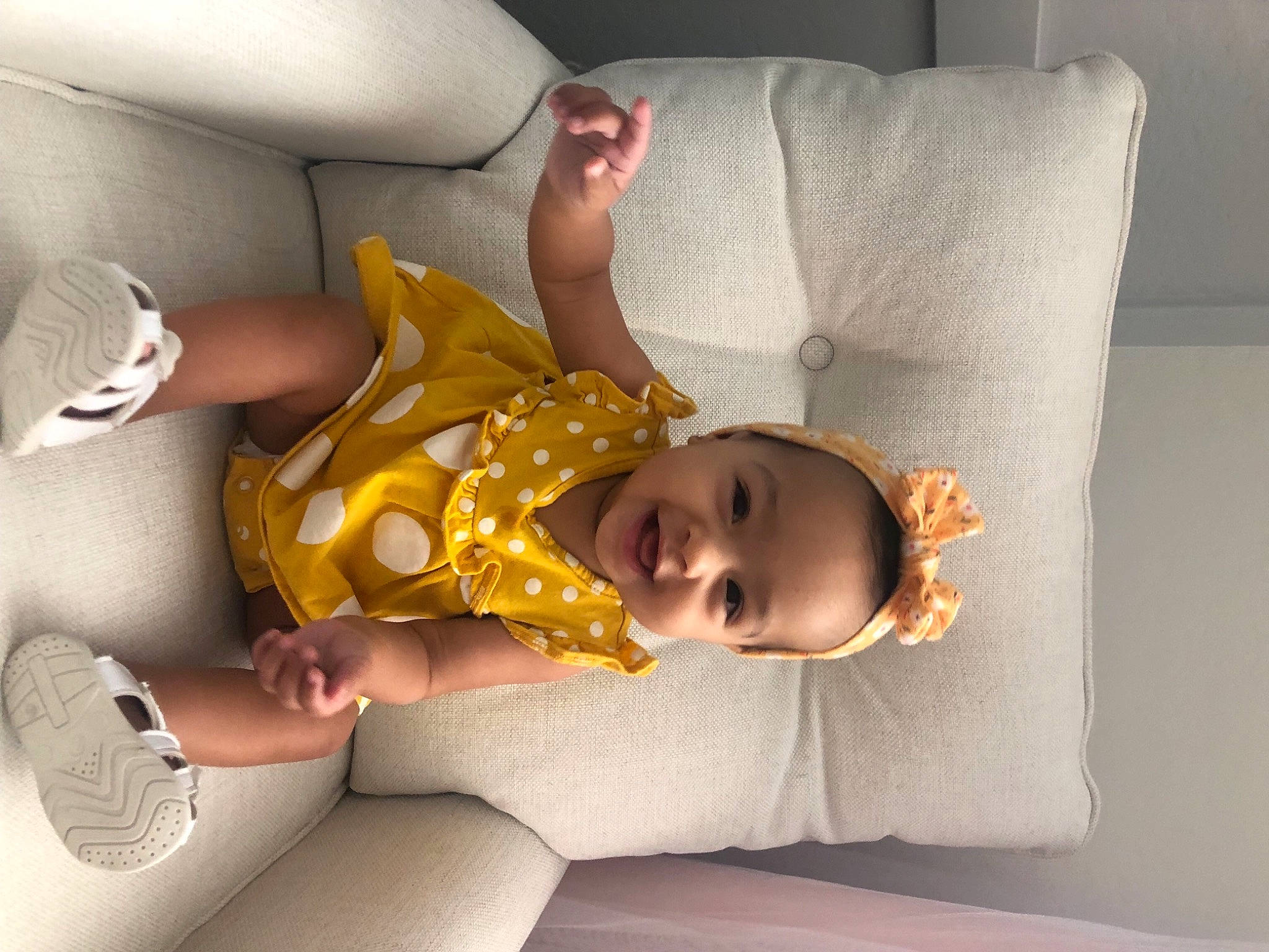 Elle is registered to the contest to win money with this photo: baby, baby_products, baby_toddler_clothing, bedding, child, comfort, couch, flooring, foot, fun, happy, human_leg, joy, knee, linens, person, room, sitting, smile, sock