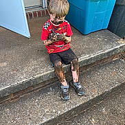 Zachariah is registered to the contest to win money with this photo: child, boy, mud, dirty, sitting, concrete, steps, red_shirt, black_shorts, sneakers, outdoor, door, blue_bin, curious, messy, play, dirt, face, hands, legs