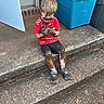 child, boy, mud, dirty, sitting, concrete, steps, red_shirt, black_shorts, sneakers, outdoor, door, blue_bin, curious, messy, play, dirt, face, hands, legs