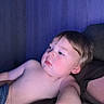 Wesley is registered to the contest to win money with this photo: toddler, child, shirtless, indoor, blue_light, relaxing, face, skin, arm, expression, young, person, portrait, casual, home, seated, hair, head, looking_away, cozy