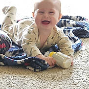 Robert is registered to the contest to win money with this photo: baby, blanket, bottle, carpet, child, clothing, cozy, crawling, cute, face, floor, happy, indoor, infant, milk, person, playtime, smiling, toy, young