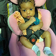 Miracle joined the competition — help win amazing prizes! baby, car_safety, car_seat, child, clothing, curly_hair, cute, expression, holding, indoor, infant, looking, pacifier, person, pink, portrait, seat_belt, small_child, socks, straps