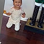 toddler, child, smiling, pajamas, indoor, wooden_floor, decorative_figure, boots, holiday, kneeling, happy, person, home, wall, floor, toy, cute, small_child, playful, expression