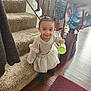Reneah joined the competition — help win amazing prizes! toddler, child, smiling, staircase, carpet, wooden_floor, cup, pigtails, indoor, clothing, sweater, skirt, black_boots, person, home, bag, railing, happy, cute, floor_mat