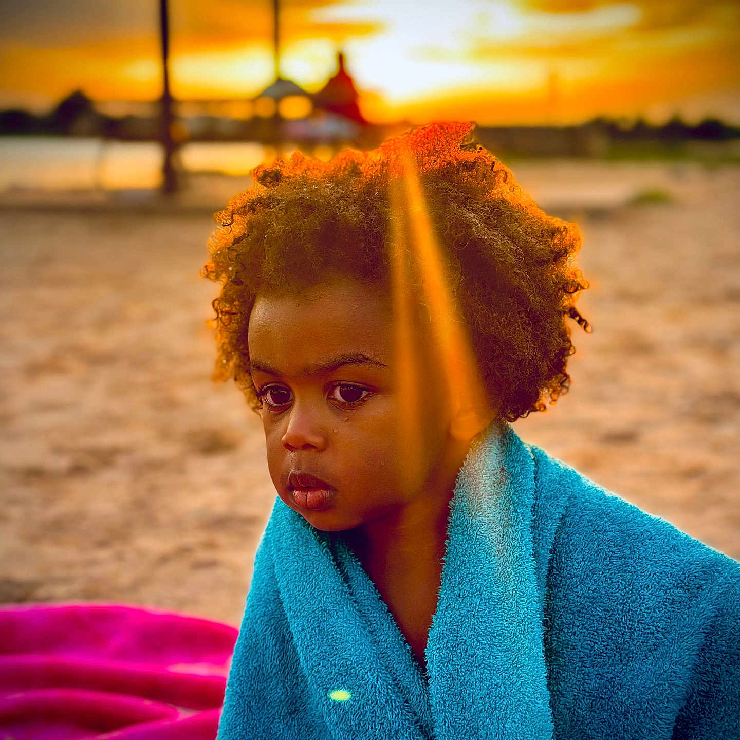 Kecy joined the competition — help win amazing prizes! beach, blue_towel, child, curly_hair, emotion, golden_hour, nature, outdoor, person, portrait, reflection, sad, sand, serene, sunbeam, sunset, tear, towel, warm_light, young